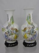 A Pair of Antique Chinese Famile Rose Vases, the vases depicting wise men beside a tree, character