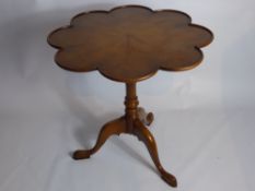 A Reproduction Mahogany and Yew Tilt Top Table, the table having a scalloped edge on hoof feet,