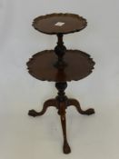 An Antique Mahogany Two Tier Occasional Table, having a scalloped edge with turned and carved ribbon