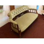 A Mahogany Edwardian Button Back Sofa, having spindle back, laurel decoration to arms, on turned