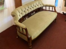 A Mahogany Edwardian Button Back Sofa, having spindle back, laurel decoration to arms, on turned