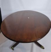 A Georgian Mahogany Oval Tilt Top Oval Table, the table on splayed reeded legs with brass ends and