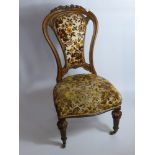 A Victorian Spoon Back Walnut Nursing Chair, the chair having carved leaves to top.