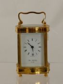 A William Widdop Brass Carriage Clock, with white enamel face and Roman dial.