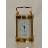 A William Widdop Brass Carriage Clock, with white enamel face and Roman dial.