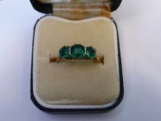 A Lady's 18 ct Yellow and White Gold 3-stone Emerald Ring, size P, centre emerald 5 x 5 mm, 2 x 4