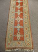 A Middle Eastern Woollen Hall Runner, of geometric design with orange ground and blue and cream