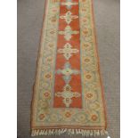 A Middle Eastern Woollen Hall Runner, of geometric design with orange ground and blue and cream