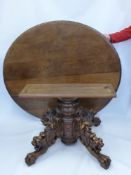 An Antique Oak Circular Dining Table, with elaborately carved column and pedestal base. The base