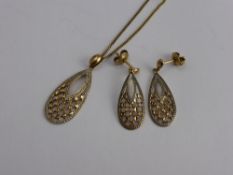 A Lady's Gold and Silver Pendant Necklace, with matching earrings.