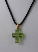 A Lalique Green Glass Cross Pendant, the pendant on silk rope tie, original box and certificate.
