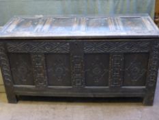 An Antique Stained Oak Coffer, with decorative carving to the front panel, hinged lid over stile