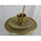 An Indian Brass Pestle and Mortar, together with a lattice work brass dish depicting Greek and