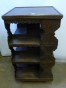 An Edwardian Carved Oak Revolving Bookcase, having three tiers with decorative carving to side