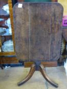 An Antique Oak Tilt-Top Table, the table having a rectangular top on turned column and tripod  base,