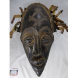 A Wooden West African Carved Death Mask, having wooden tubular dreadlocks.