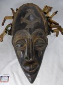 A Wooden West African Carved Death Mask, having wooden tubular dreadlocks.