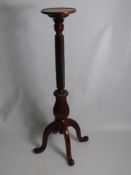 A Mahogany Torchere, the torchere with ribbon turned column on scroll feet, approx 120 cms high.