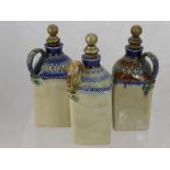 Three 19th Century Royal Doulton Lambeth Ware Decanters, with decorative glaze to the top and