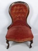 A Victorian Oak Nursing Chair, with turned supports and porcelain castors.