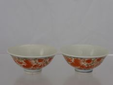 A pair of Chinese porcelain bowls depicting red phoenix in flight with chrysanthemum and scroll leaf