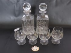 Two Whisky Decanters with a porcelain brandy label and four brandy glasses.