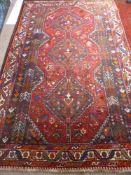 A Woollen Hand Woven Kashtai Iranian Rug, the rug having two central medallions with tribal and