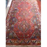 A Woollen Hand Woven Kashtai Iranian Rug, the rug having two central medallions with tribal and