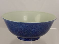 A deep blue Chinese porcelain bowl depicting dragons amongst cloud scrolls and flaming pearls of