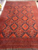 A Woollen Middle Eastern Carpet, the carpet having red, midnight blue and white background with