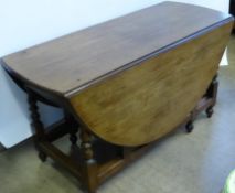 A George III Mahogany Oval Gate Leg Dining Table, the dining table having turned supports with