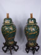 A Pair of Famille Verte Style Temple Vases and Rosewood Stands, painted with figural scenes with