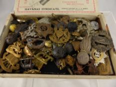 A Box Containing Military Badges, including caps and collar badges.