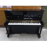 An upright piano in a black polyester case
