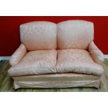A two seater sofa having padded back supports and arms upholstered in a rose floral fabric raised on