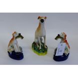 A pair of Staffordshire greyhound pen holders, each modelled sitting with dead game, together with a