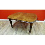 A late Victorian mahogany dining table having a moulded top and two extra leaves raised on bulbous