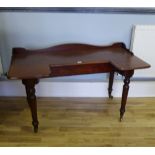 A late Victorian ledgeback mahogany wash stand having a moulded top raised on turned supports, 140 x