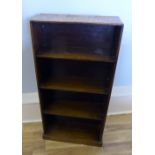 A 1930s oak bookcase of small proportions, having three fixed shelves raised on a fixed plinth base,