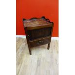 A Georgian mahogany commode with the three quarter gallery top above a tambour front and pull put