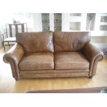 Pair of leather three seater couches on bun feet