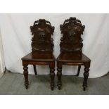 Pair of mid 19th century mahogany hall chairs with carved backs on turned baluster legs