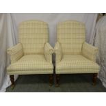 Pair of upholstered high backed arm chairs on four turned mahogany legs, with original castors