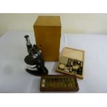 A microscope in fitted case, a quantity of prepared slides and accessories, to include lenses