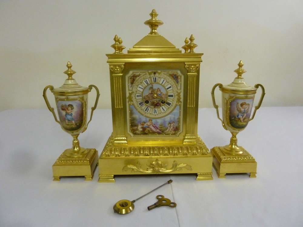 A 19th century French clock set, architectural form, gilt metal, two train movement, Roman