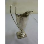 A George III silver cream jug, oval with beaded border and reeded loop handle on square base, London