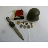 A quantity of German WWII memorabilia to include dagger, badges, helmet and flag