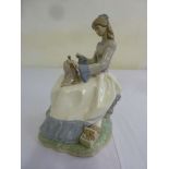 Nao figurine of a girl seated sewing