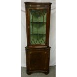 Mahogany corner cabinet of concave form with hinged glazed door on bracket feet