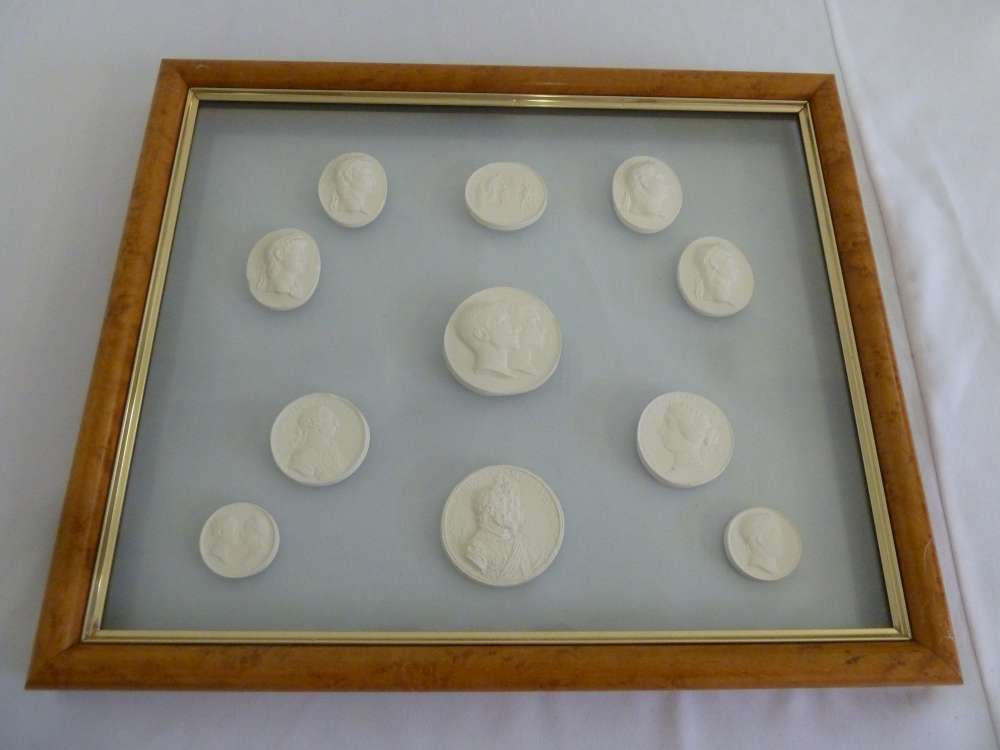 Eleven classical plaster casts in glazed maple wood frame